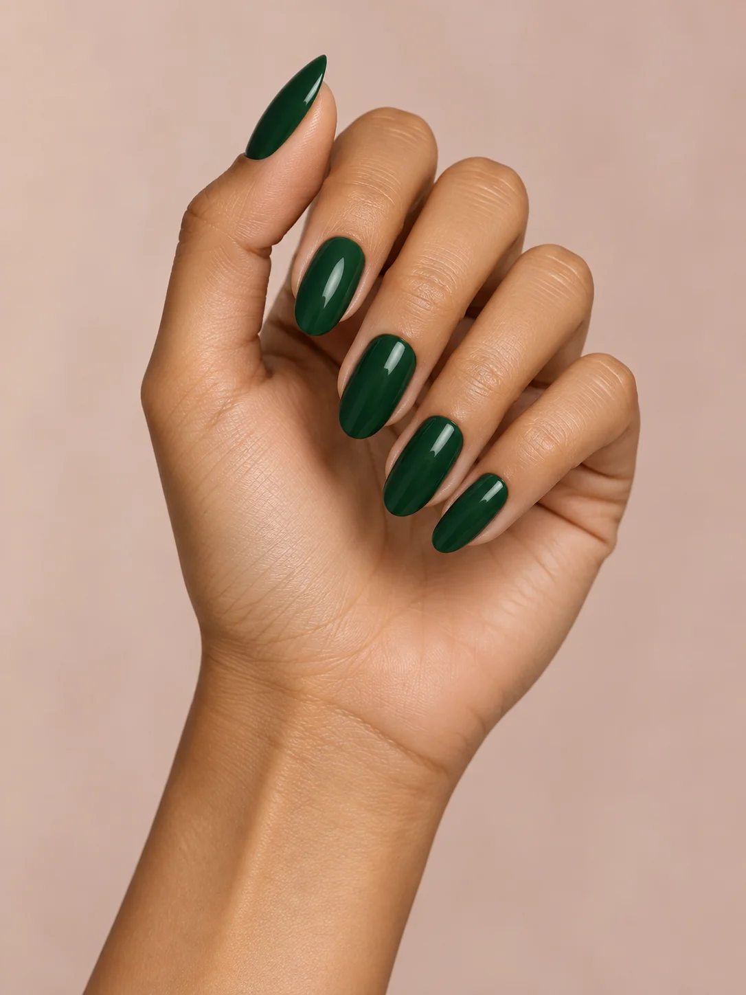Deep emerald-green polish gives medium almond nails a jewel-like richness.