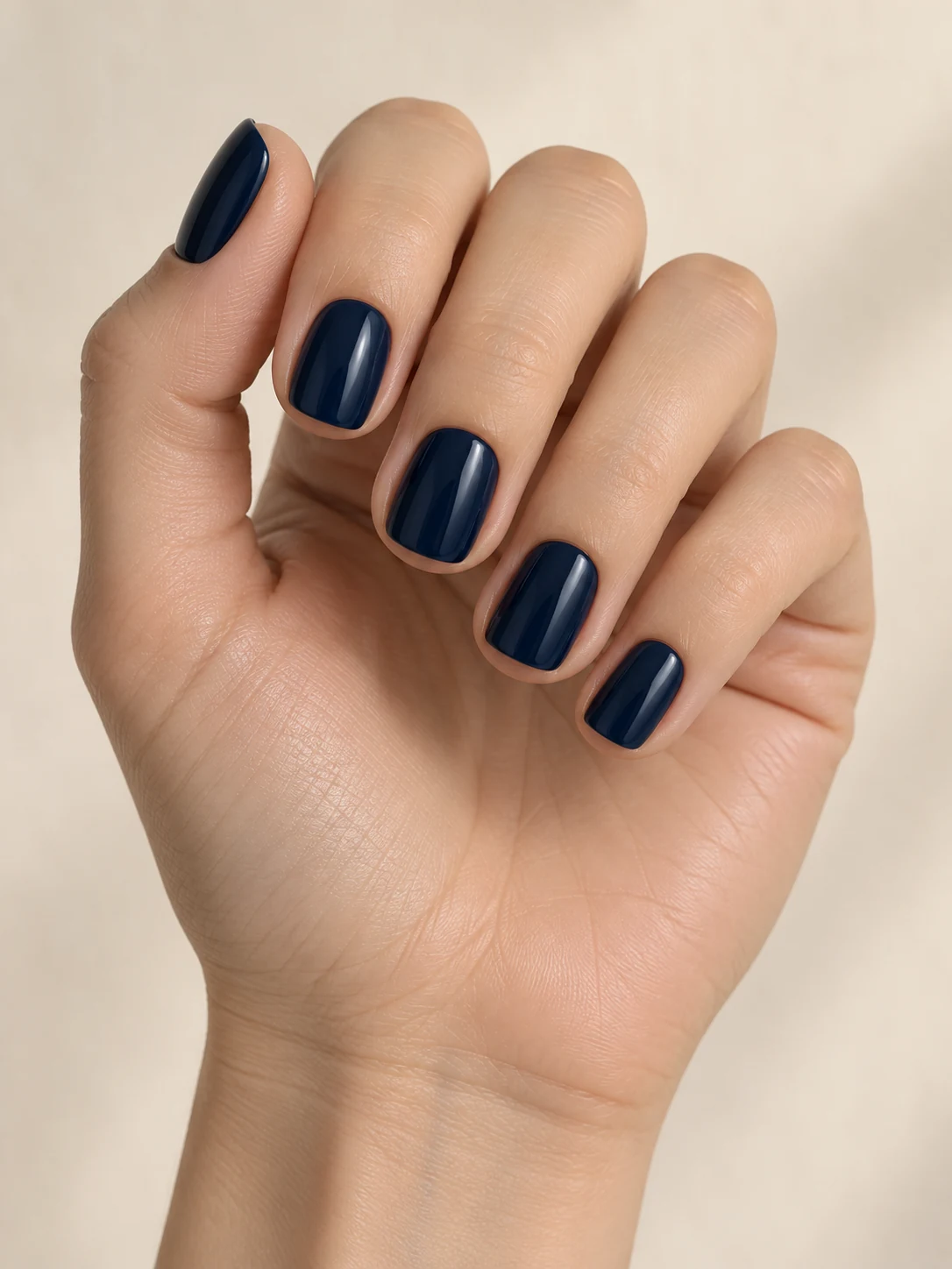Short squoval nails painted in deep midnight navy with a glossy tailored finish, no stars or extra art on fair neutral skin; short squoval manicure.