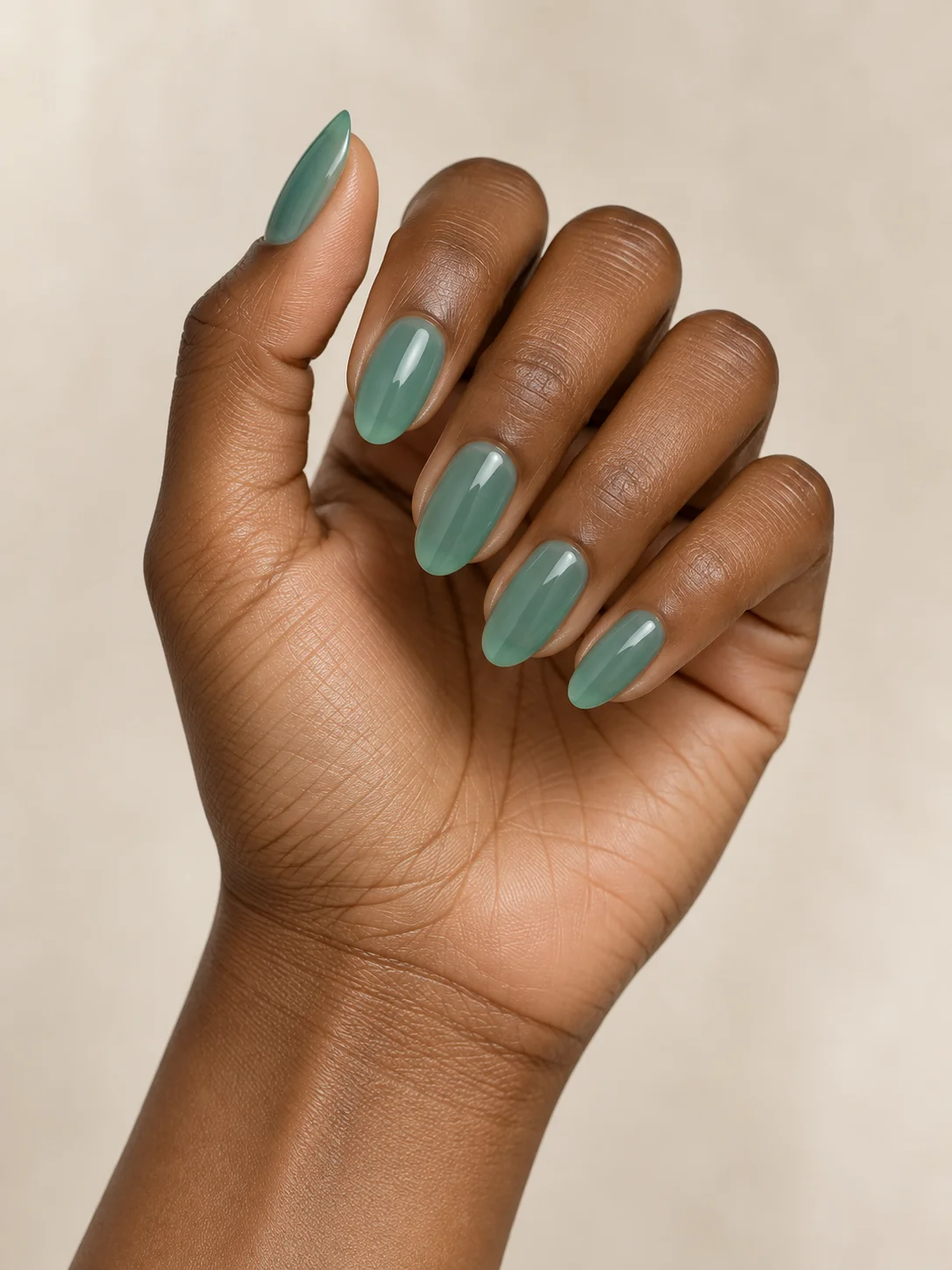 Translucent aqua-green jelly polish gives medium oval nails a glass-like depth.