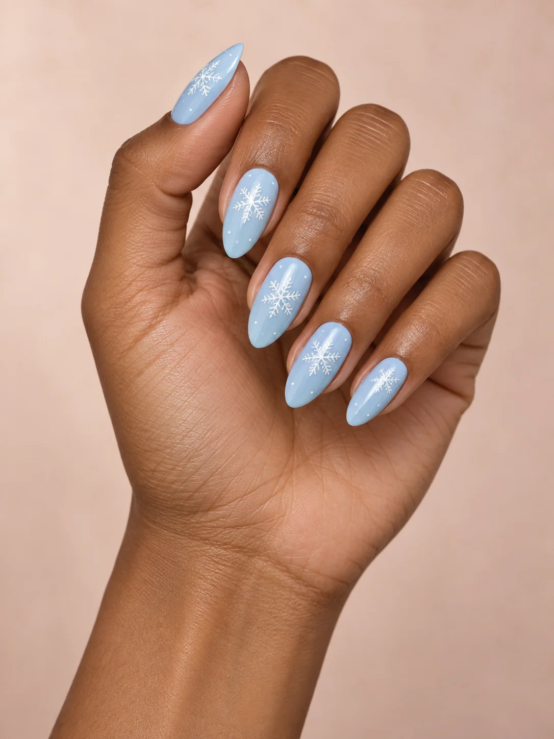 Fine white snowflakes settle over a pale blue base on medium almond nails.