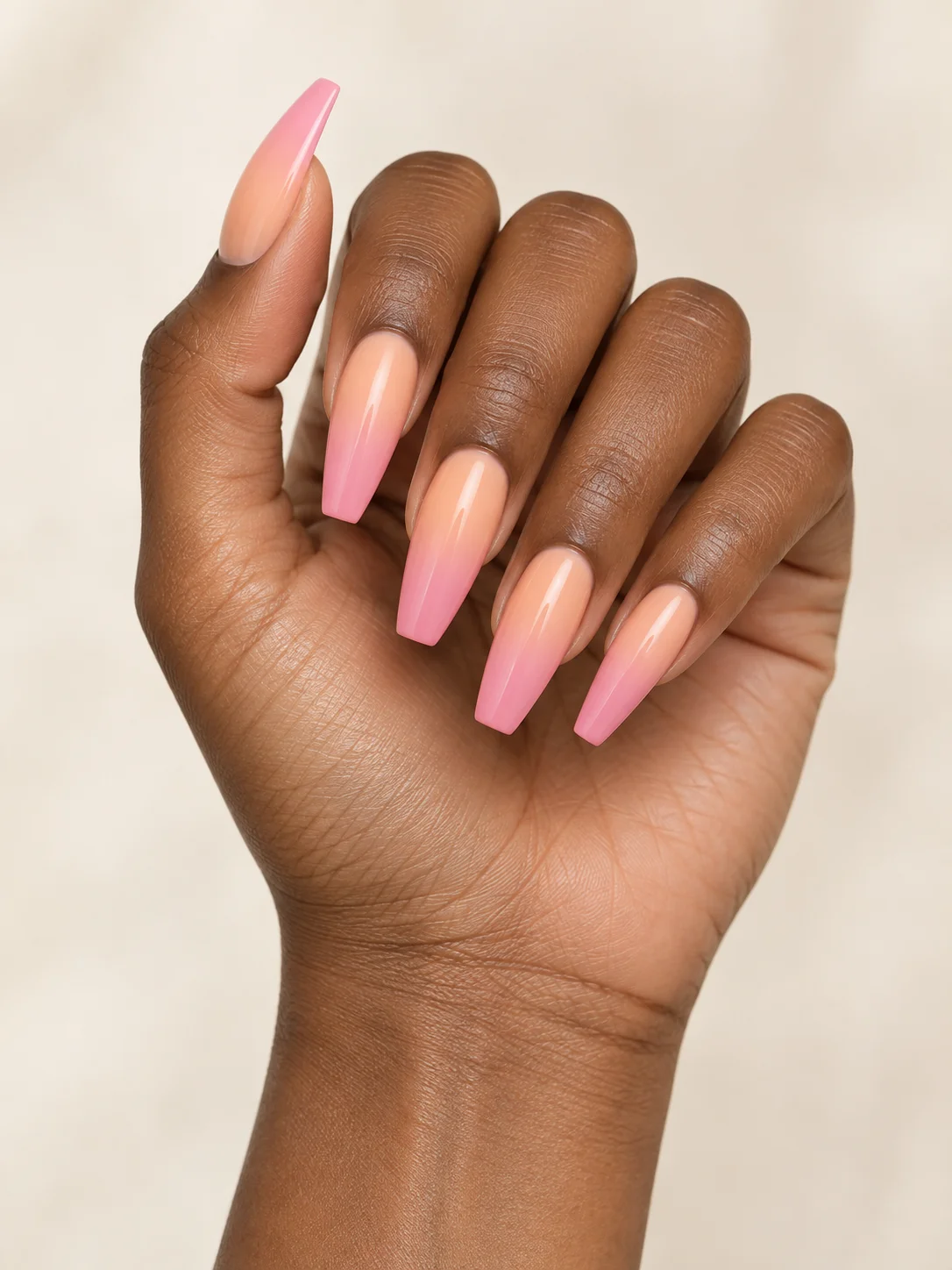 Peach blends softly into pink across long coffin nails for a warm sunset gradient.